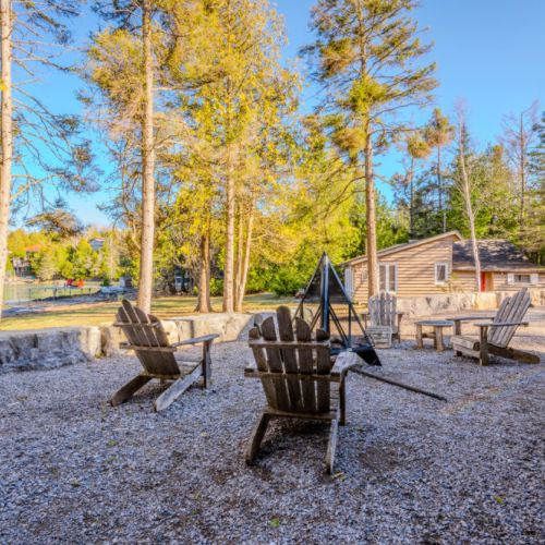 Soak up the sunshine at this serene vacation rental, featuring a rustic outdoor fire pit area with Adirondack chairs—perfect for cozy lakeside gatherings, nature escapes, and unforgettable cottage country retreats.