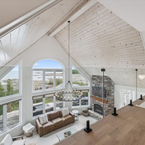 Natural light floods the great room, guiding you to a sun-soaked living area with incredible lake views.