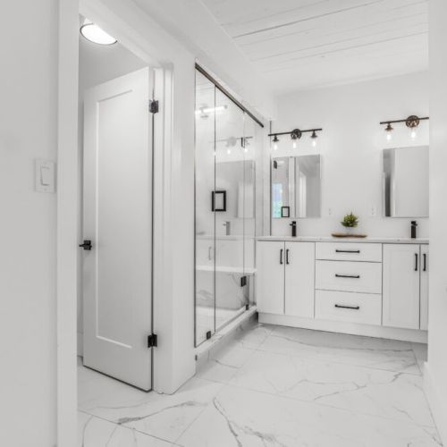 Fresh spa style bathroom with double sinks and a roomy glass shower.