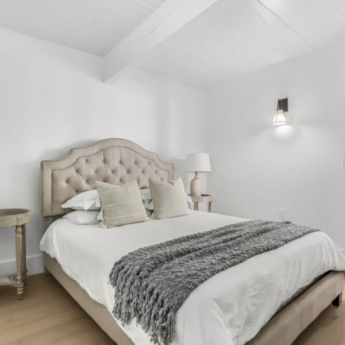 Cozy bedroom with a plush bed soft linens and a warm relaxing feel.