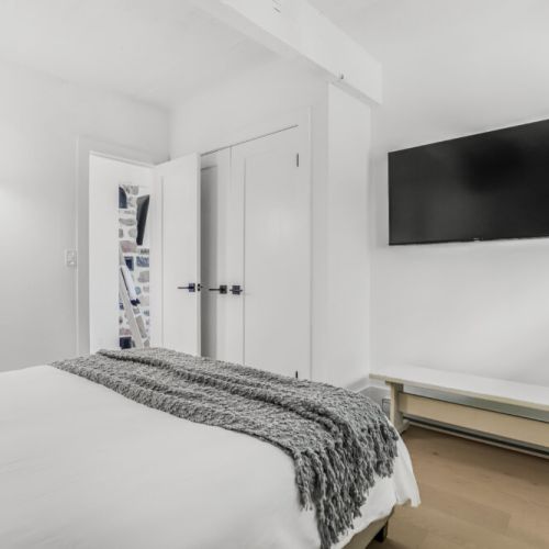 Bedroom with a wall mounted TV and easy storage for a comfortable stay.