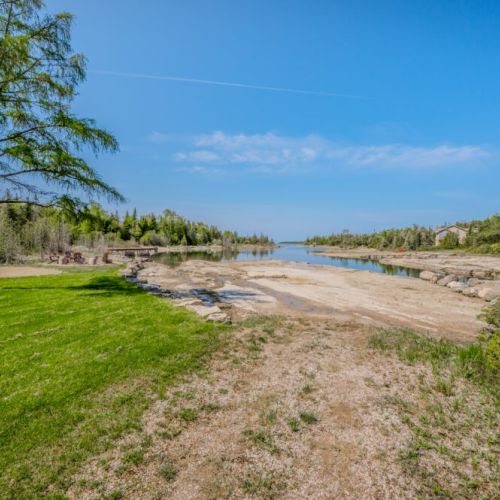 A beautifully manicured lawn stretches towards the water, providing ample space for outdoor activities and picturesque views.