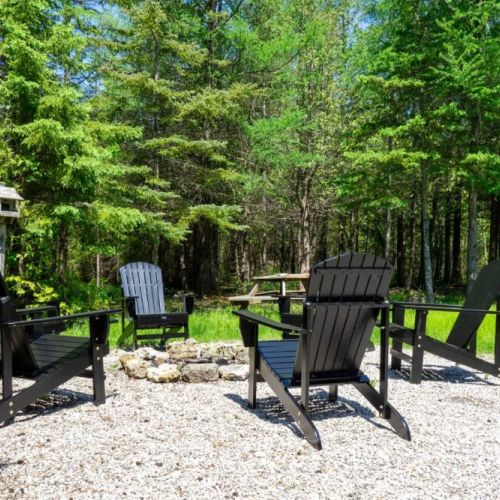Gather around the private fire pit with stylish Adirondack seating—an ideal evening spot for wine, chats, and quiet moments in nature.