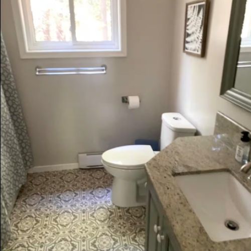 Bright and clean main bathroom featuring a full shower, modern fixtures, and thoughtful details for your comfort.