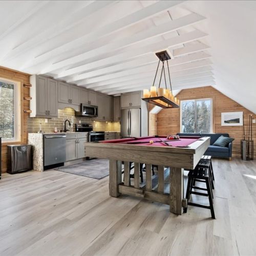 Open-concept living space with full kitchen, seating, and a pool table for added fun. Bright, welcoming, and designed for comfortable extended stays.