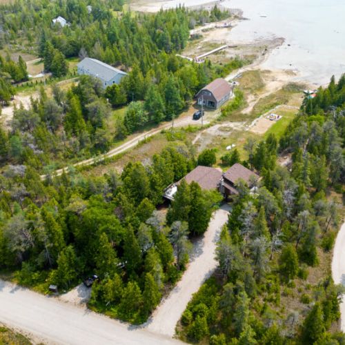 Nestled between trees overlooking the water.