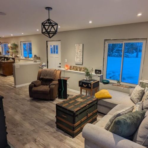 Relaxing seating area with large windows bringing in natural light and views of the surrounding countryside.