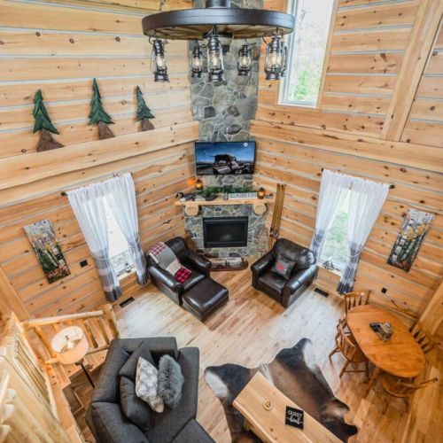 Overlooking the great room, the loft offers a unique perspective on the open living space below, highlighting the intricate craftsmanship and inviting atmosphere of Saw N' LogzzZ.