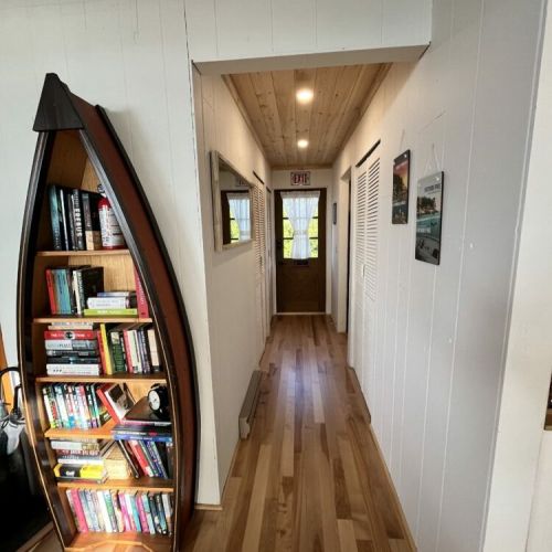 A charming hallway adorned with a unique boat-shaped bookshelf, adding character and providing a selection of reading materials for guests.