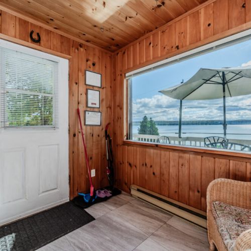 Step into the cottage and immediately take in the picturesque view of the bay through the large window, creating a warm and inviting atmosphere.