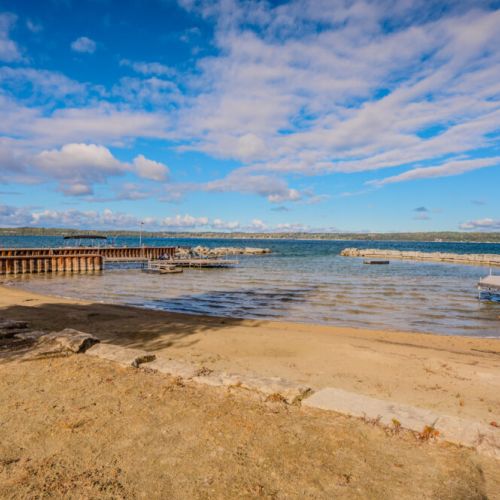 A pristine stretch of sandy shoreline, ideal for relaxing and enjoying the waterfront views.