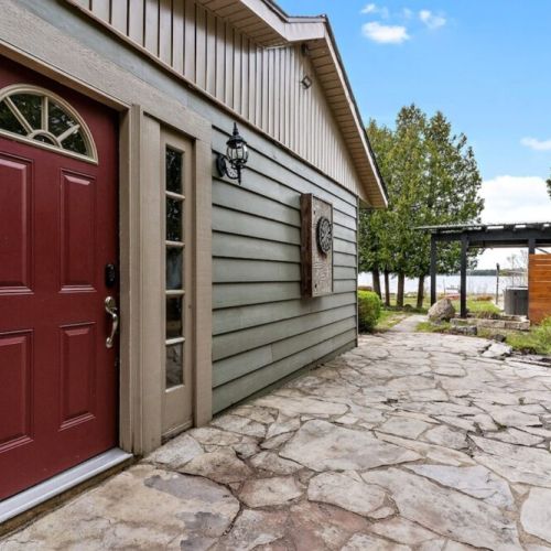 The East side maroon door with a view to the water and hot tub area.