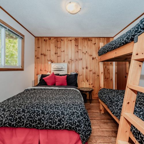 Family-friendly bedroom featuring a double bed and bunk beds — a great setup for kids or extra guests during your lakeside retreat.