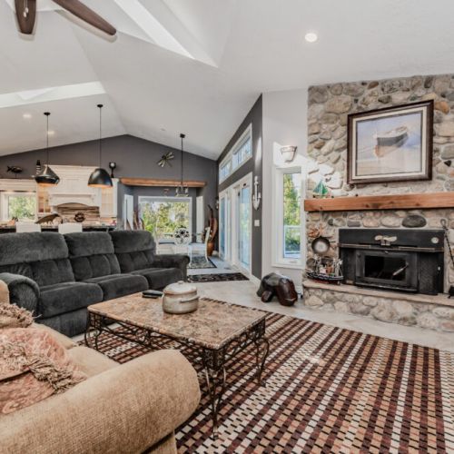 Relax fireside in this cozy, rustic-chic vacation rental. With a stone hearth, comfy seating, and open-concept flow, it's the perfect retreat after lakeside adventures or forest hikes.