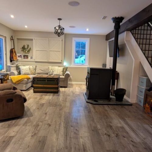 Cozy lounge space featuring a wood stove and open layout connecting the main living areas.