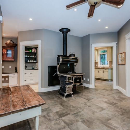 This cozy room features a vintage wood-burning stove as its centerpiece, complemented by rustic decor and modern accents, creating a warm and inviting atmosphere.