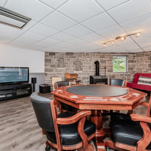 🎲 **Game Night Ready**  
Perfect for your vacation getaway, this lower-level entertainment space features a poker table, cozy wood stove, large TV, and ample seating—ideal for family games, movie nights, or relaxing après-adventure fun.