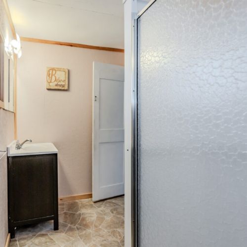 The cabin’s bathroom includes a separate shower area, offering a private space for freshening up.