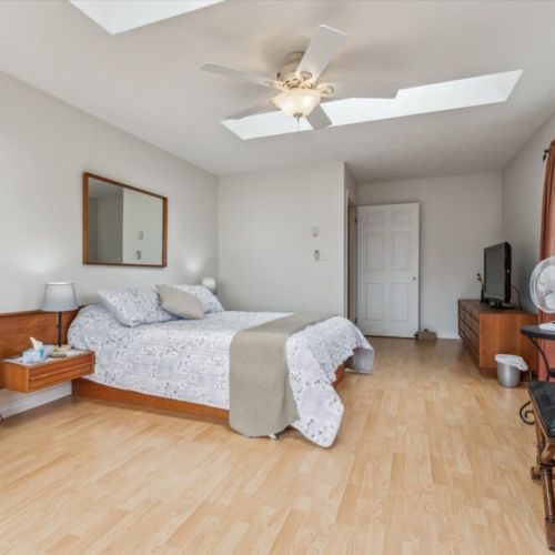 Spacious master with thoughtful furnishings – Includes TV, dresser, ceiling fan, and ensuite feel with plenty of natural light.