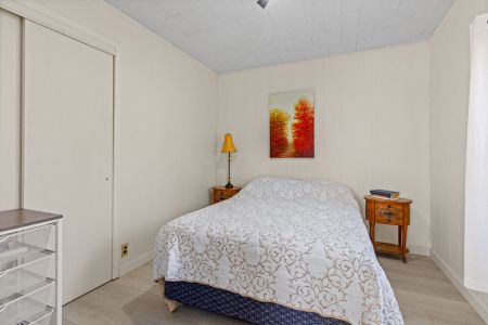 A comfortable main-floor bedroom with a cozy bed, bedside lighting and plenty of space to settle in.