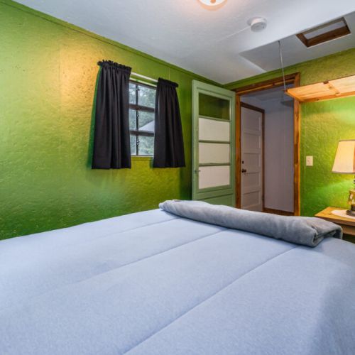 Awake to the lush, leafy views in this cozy bedroom that brings the vibrant hues of nature indoors for a serene sleeping experience.