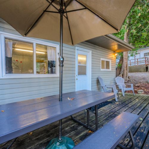The deck offers a shaded picnic table and views of the surrounding nature, providing a tranquil spot to enjoy your morning coffee or evening gatherings.