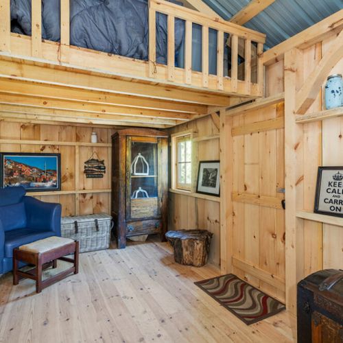 The rustic bunkhouse features warm wood interiors and a loft sleeping area for a true cottage experience.