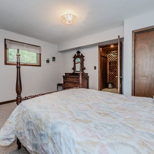 Bright primary suite with beautiful wood accents, offering a cozy retreat after days of beach fun and lake adventures.