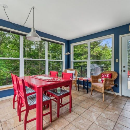 Sunroom dining nook with lake views—enjoy breakfast surrounded by nature in this inviting space.