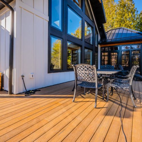 Bask in the sun on the spacious deck of this modern vacation rental, featuring elegant patio seating, forest views, and a seamless indoor-outdoor living experience—perfect for getaways, retreats, and lakeside relaxation.