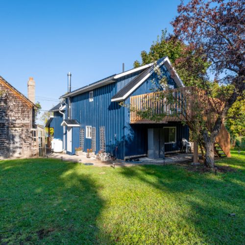 The exterior showcases a delightful mix of rustic charm and modern design, set against a backdrop of beautiful trees.