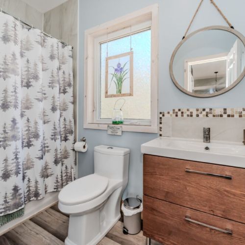 Freshen up in a bright, modern bathroom with woodland-themed charm—clean, cozy, and ideal after a day of exploring nature trails or kayaking.