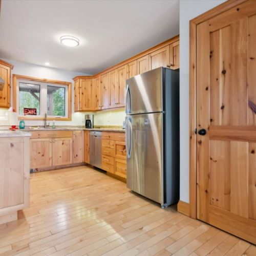 Enjoy a fully equipped kitchen with warm wood cabinetry and modern stainless steel appliances for easy cottage meals.