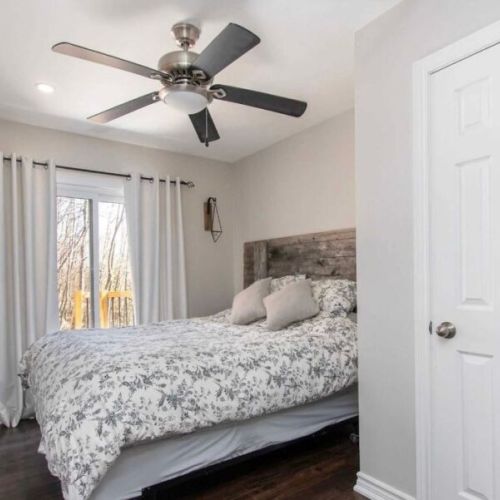 Spacious main floor bedroom with forest views and natural light.