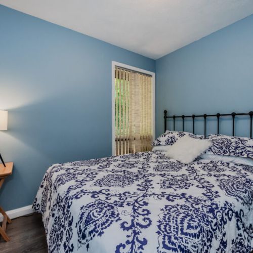 This cozy bedroom features calming blue walls and soft bedding, creating a restful atmosphere for a peaceful night’s sleep.