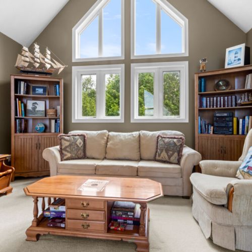 A cozy loft sitting area framed by large windows — the perfect spot to unwind, read, or enjoy a quiet afternoon.