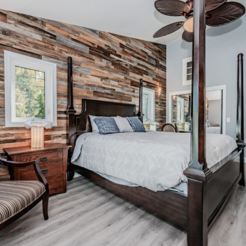 Elegant master suite with four-poster bed, flat screen TV, and access to a private deck—perfect for your lakeside escape.