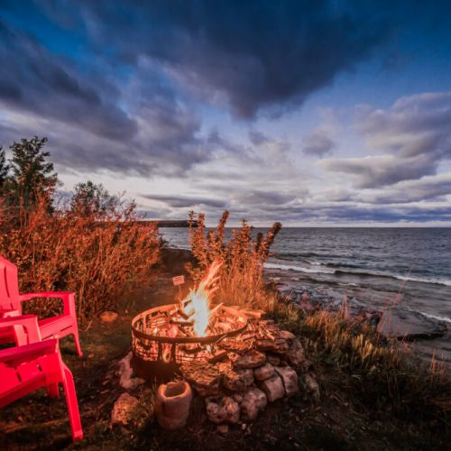Charming home exterior at dusk, overlooking the beautiful waterfront.