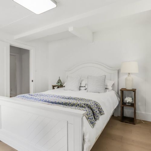 Another bright bedroom with a comfy bed and a calm cottage vibe.