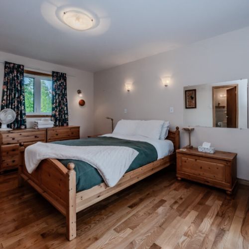 Peaceful bedroom with a cozy chair and natural light, offering a quiet retreat at the end of your day exploring Lake Huron’s shoreline.