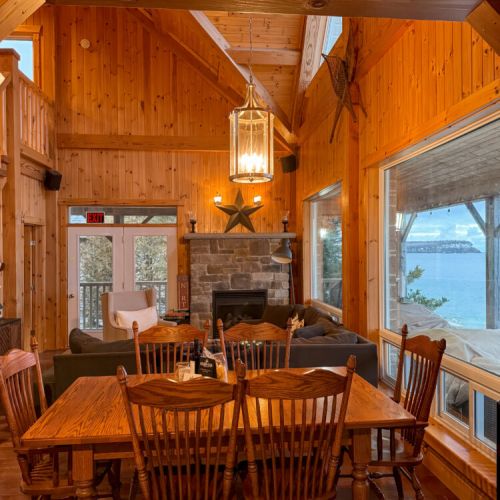 Gather around the spacious dining table with lake views and a cozy fireplace—ideal for family vacations, group getaways, and memorable cottage escapes.