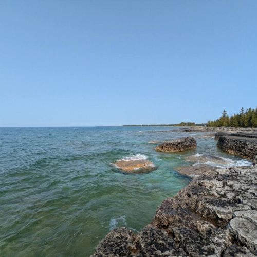 Stroll along the stunning Bruce Peninsula shoreline with turquoise waters and dramatic rock formations—perfect for nature lovers and photographers.