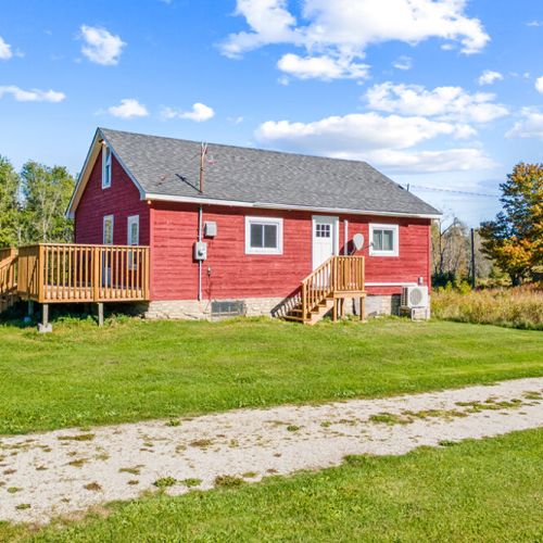 Smith Homestead’s classic red farmhouse sits peacefully among open lawns, fields and surrounding forest.