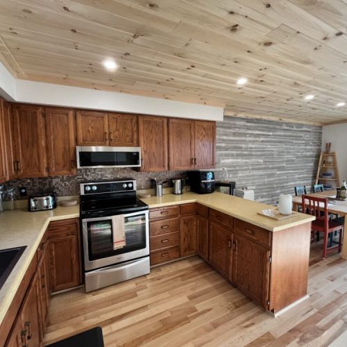 Spacious with ample counter space and wooden cabinetry, designed to make meal preparation a breeze. The modern stainless steel appliances blend seamlessly with the rustic decor.