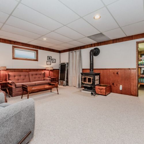 Rustic family lounge with a wood-burning stove – unwind after a day of swimming, hiking, and cottage fun.