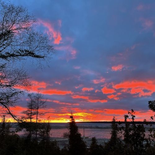 Dramatic sky at dawn or dusk with vibrant hues of pink and orange, offering a spectacular view from the cottage.