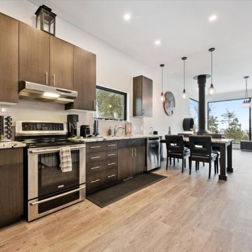 A sleek, open kitchen with stainless appliances, modern cabinetry, and an easy flow into the dining and living areas.