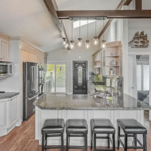 Island seating with open sightlines to the living area and deck access. Ideal for family meals and seamless indoor-outdoor travel.