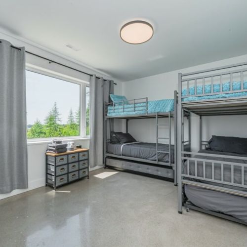 Aqua-Blue kids room with massive bunk beds and trundle pull-outs, smart phone charging station and alarm clock.