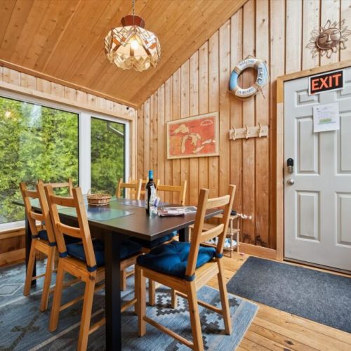 Enjoy meals together at the dining table while taking in peaceful views of the surrounding trees through the large windows.